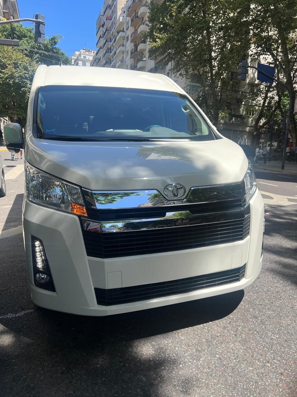 Toyota HiAce blanca frente ciudad